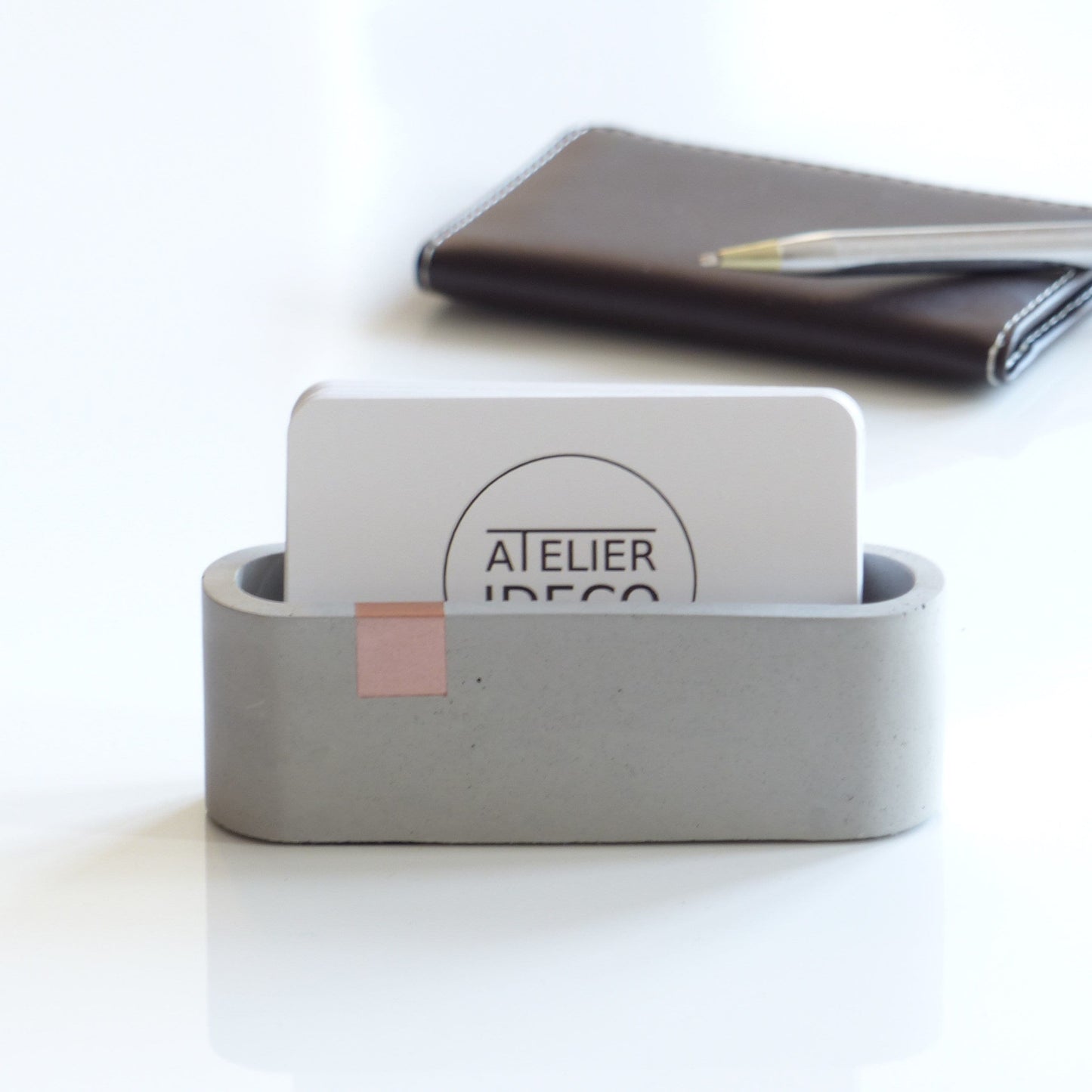 Gray business card stand with rose gold accent