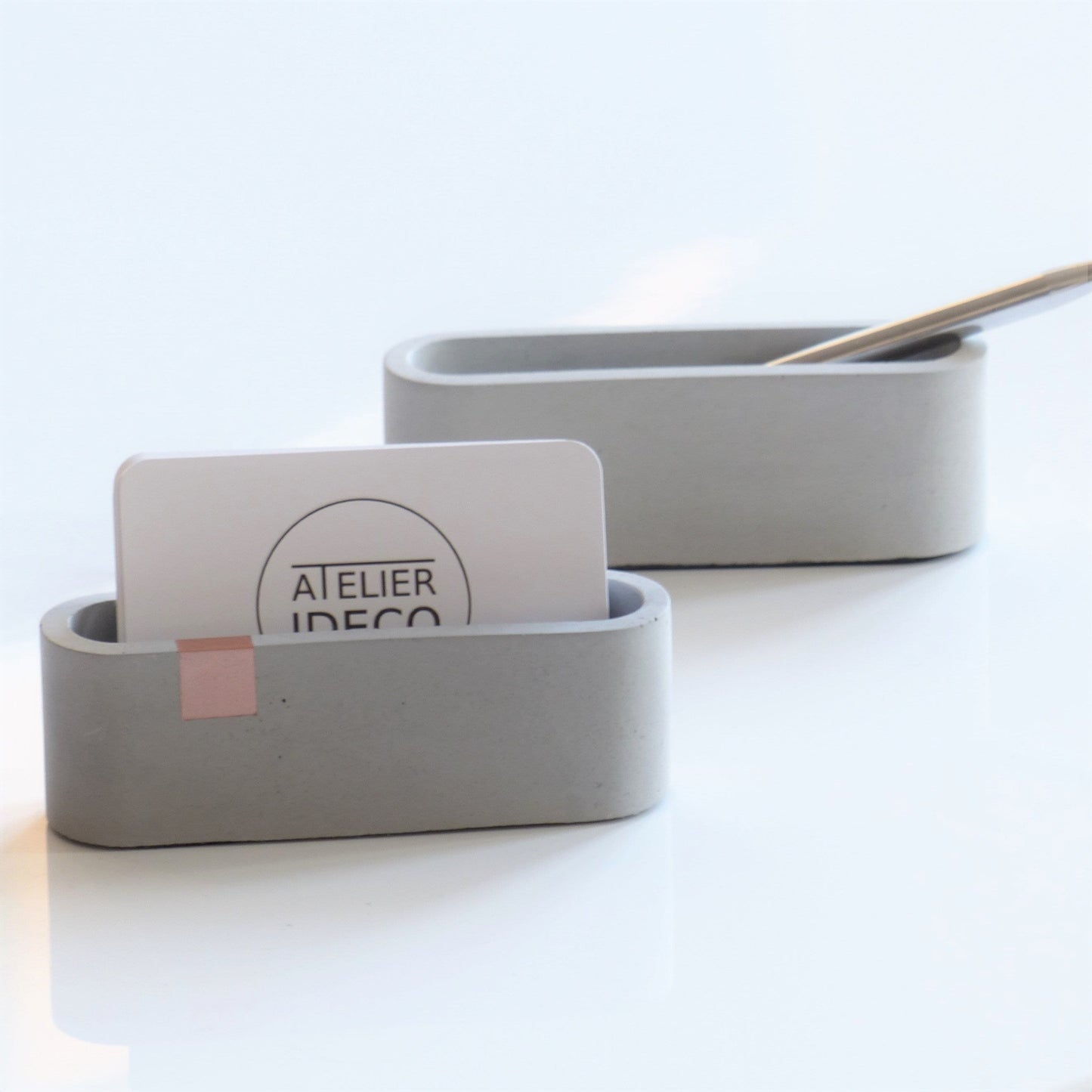 Gray business card stand with rose gold accent
